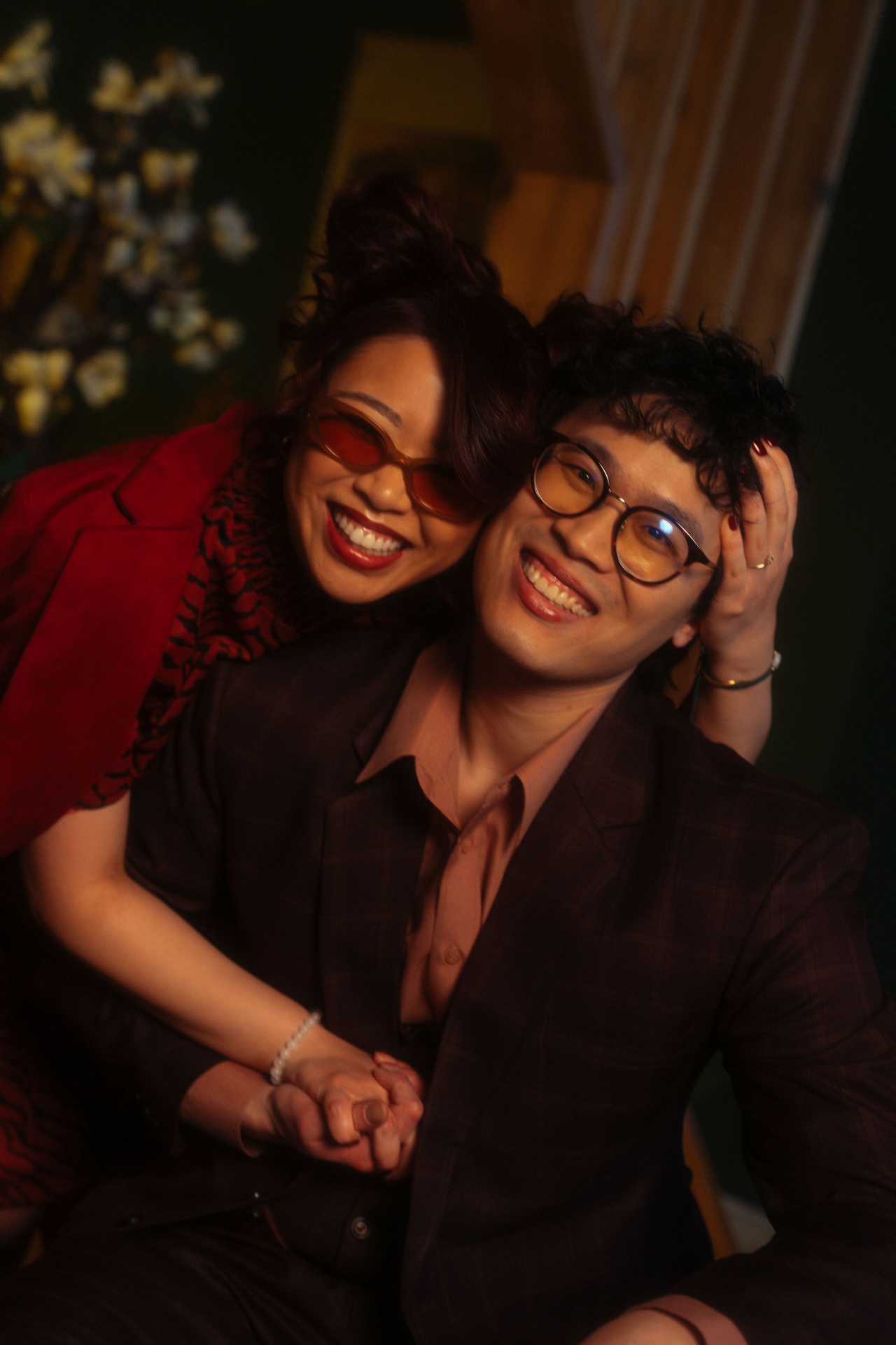 Teck Yan and Julie cheek to cheek, laughing in warm tungsten light